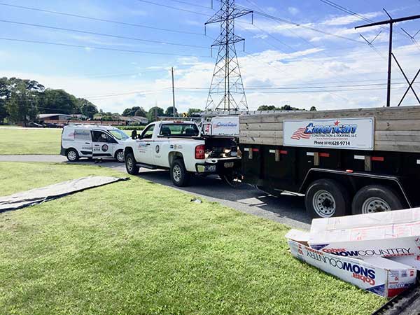 American Construction & Roofing work trucks at a job site